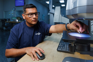 precision resource employee examining a critical part component